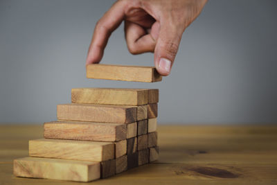 Close-up of hand holding stack of wood