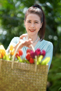 Close-up of a smiling young woman holding basket
