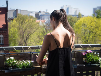 Rear view of woman standing in balcony