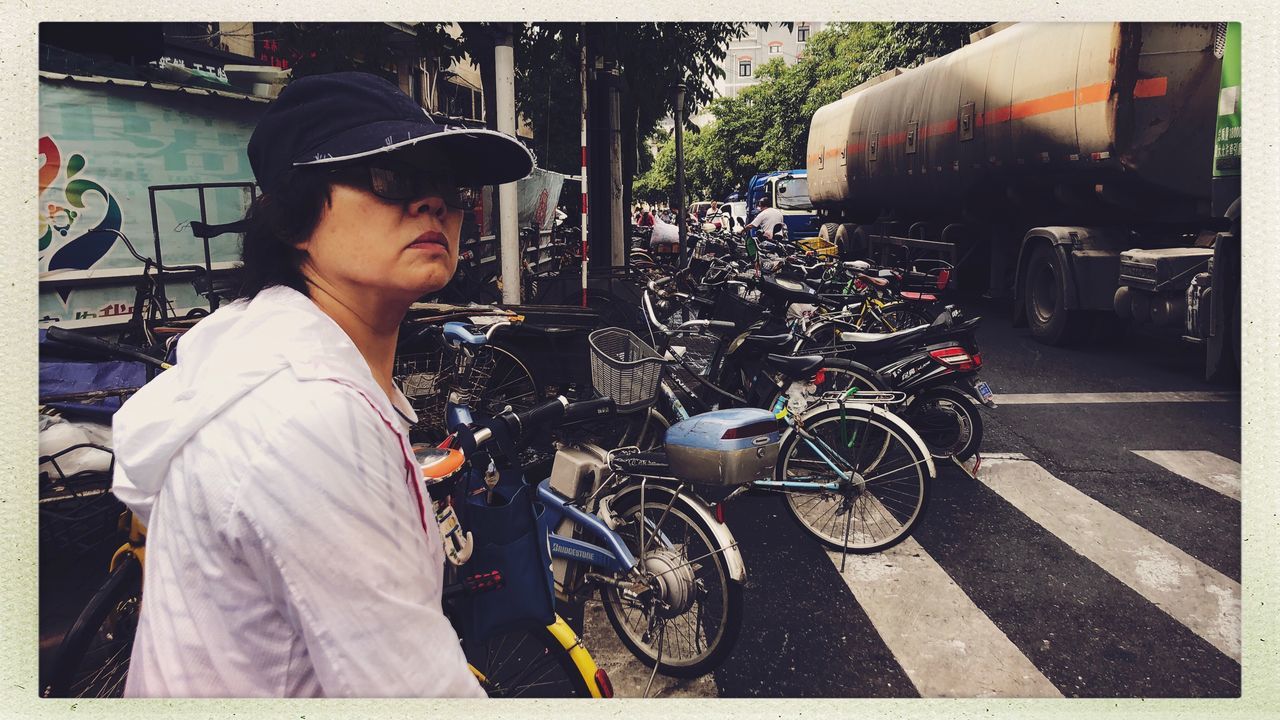 mode of transportation, transportation, transfer print, one person, auto post production filter, land vehicle, real people, city, young men, street, men, young adult, day, cap, clothing, bicycle, lifestyles, motorcycle, incidental people, outdoors