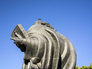 Low angle view of statue against clear blue sky