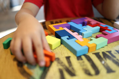 Midsection of child playing with toy blocks on table