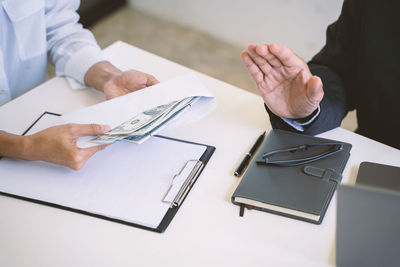 Cropped image of man using laptop on table