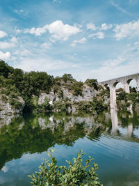 Arch bridge over river against sky