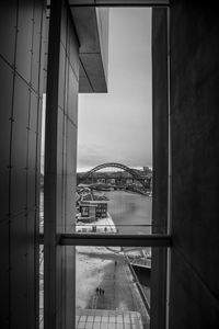 Buildings against sky seen through glass window