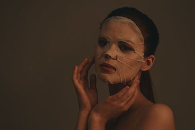 Portrait of young woman against wall