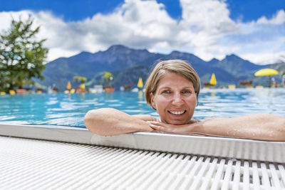 Portrait of smiling woman relaxing in swimming pool