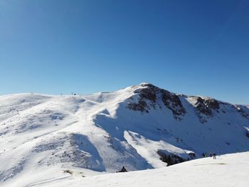 Scenic view of snowcapped mountains against clear blue sky