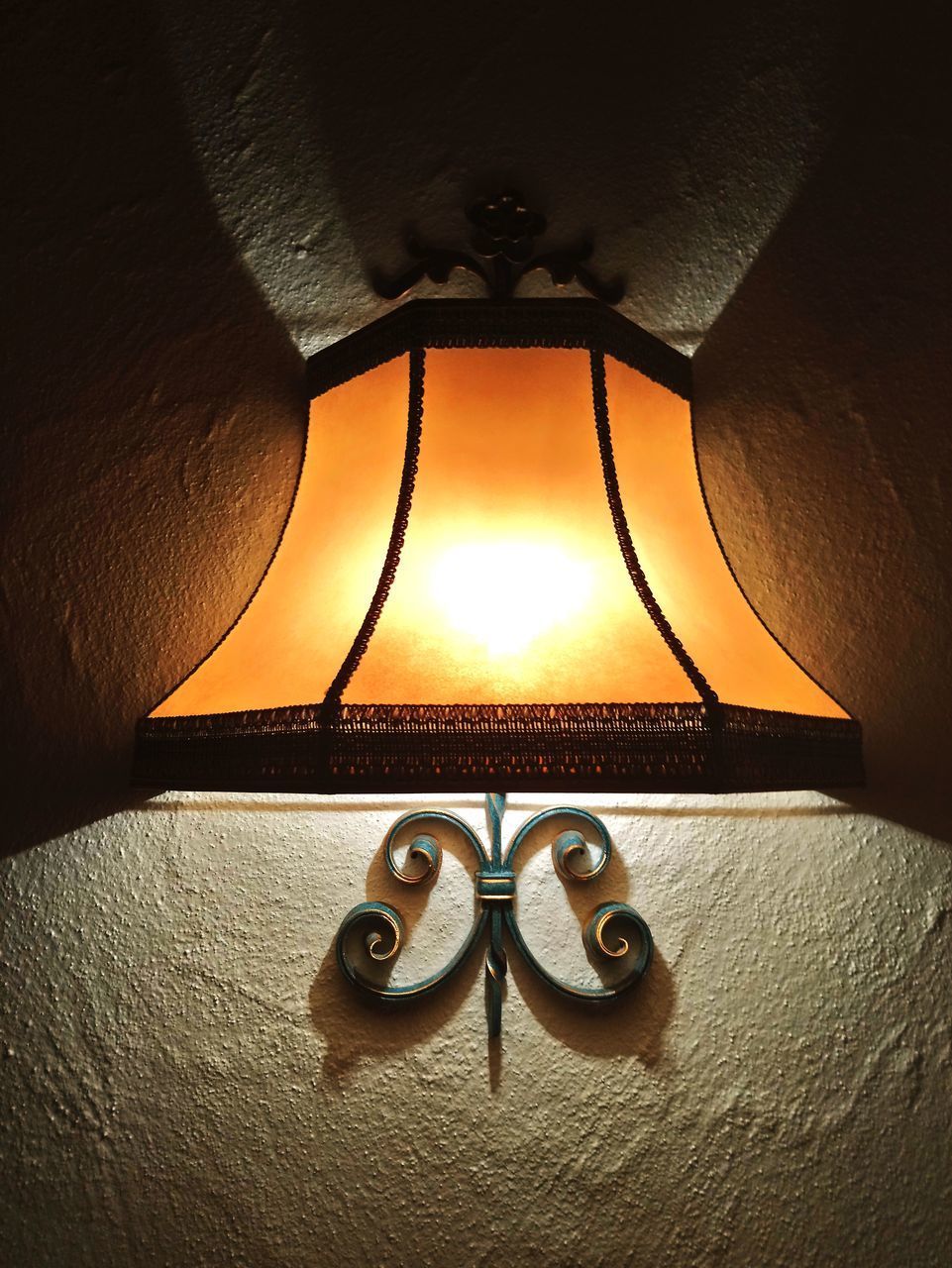 CLOSE-UP OF ILLUMINATED ELECTRIC LAMP AGAINST WALL