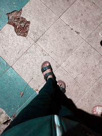 Low section of man standing on tiled floor