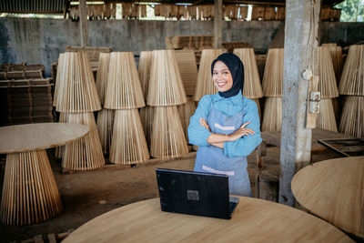 Portrait of young woman using digital tablet while sitting at home