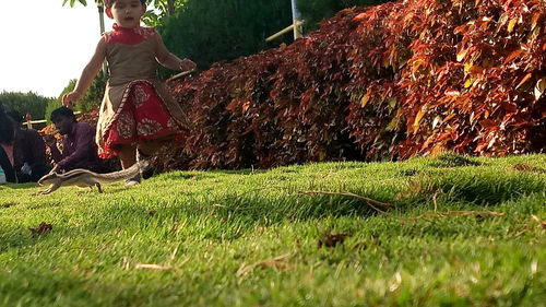 Low section of woman walking on grassy field