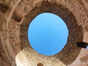 Low angle view of blue sky seen through hole