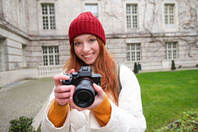Portrait of woman photographing with camera