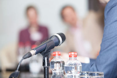 Close-up of microphone and bottles on table