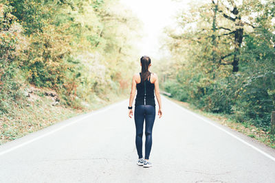 Rear view of woman walking on road