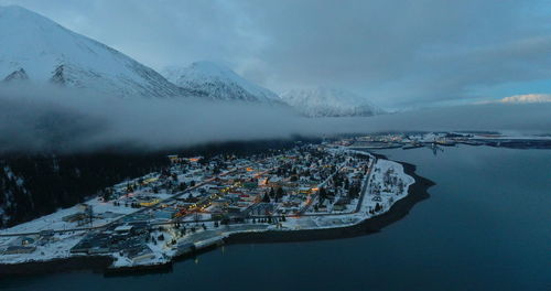 Aerial view of snowcapped mountains and sea against sky