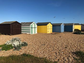 Houses on beach against clear blue sky