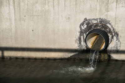 Close-up of water falling from pipe on wall