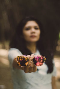 Close-up of woman holding sunglasses with reflection