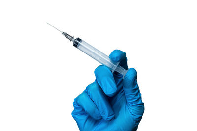 Close-up of hand holding umbrella against white background