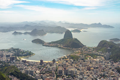 High angle view of townscape by sea against sky