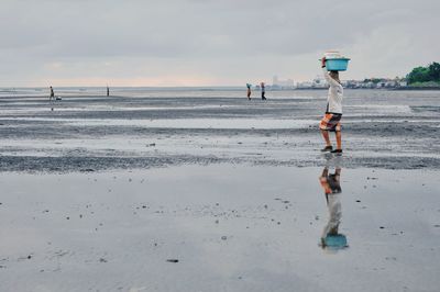 Scenic view of wet beach against sky