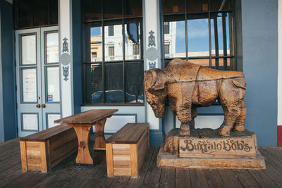 Statues on table against window