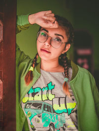 Portrait of young woman wearing eyeglasses while standing at home