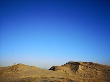 Scenic view of dunes against clear blue sky