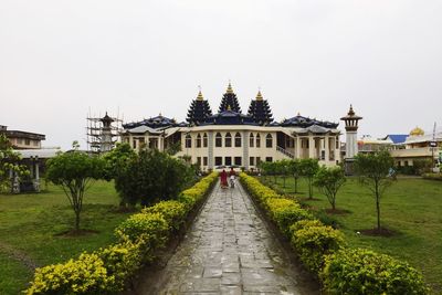 Footpath at temple against sky