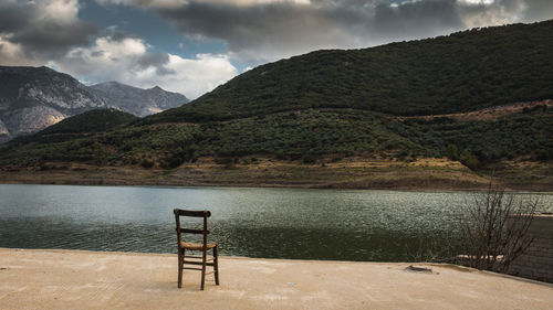 Scenic view of lake and mountains against stormy sky