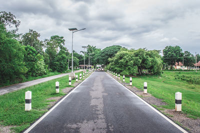 Street amidst trees against sky