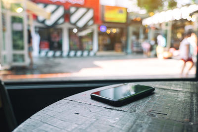 Close-up of smart phone on table at cafe