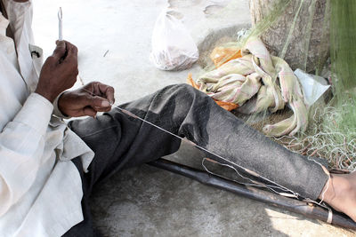 Low section of man holding fishing net