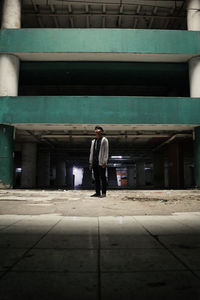 Full length portrait of young man standing against built structure