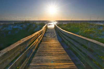 Boardwalk amidst sea against sky