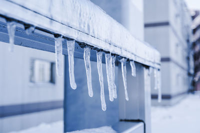 Close-up of icicles hanging on building during winter