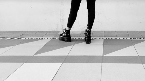 Low section of woman standing on tiled floor