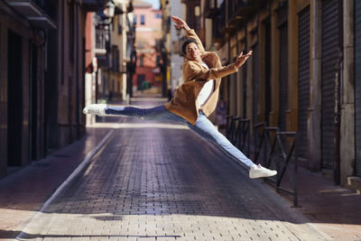 Full length of man jumping in city