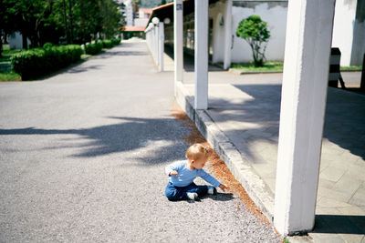 Rear view of girl sitting on floor