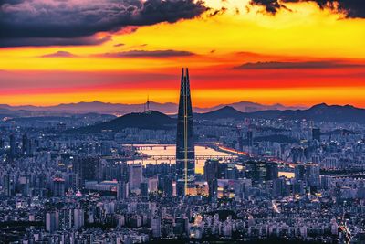 Aerial view of cityscape against cloudy sky during sunset