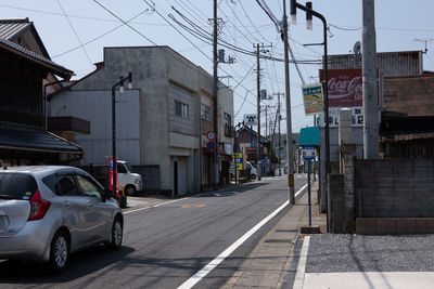 Cars on road by buildings in city