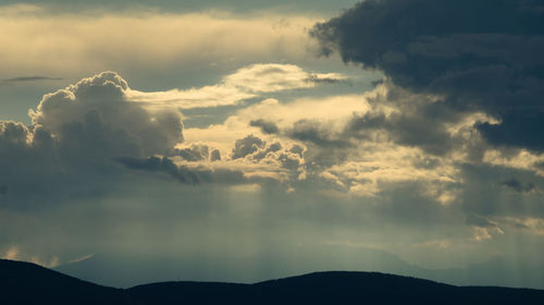 Low angle view of silhouette mountain against dramatic sky