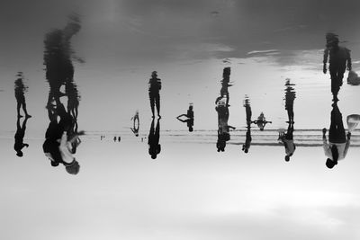 People at beach against sky