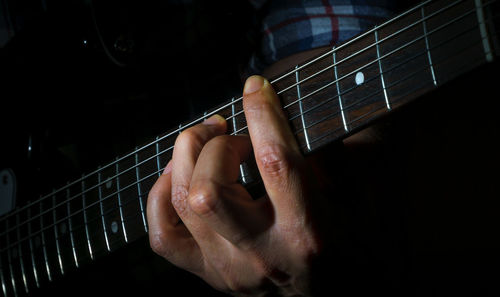 Close-up of hands playing guitar