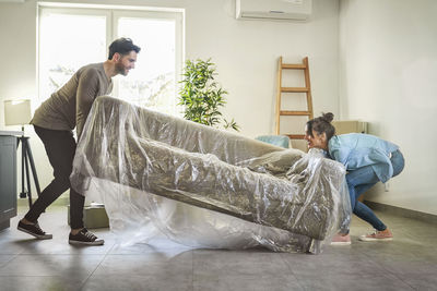 Side view of man sitting on sofa at home