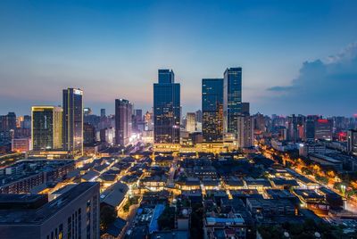 High angle view of illuminated buildings against sky at dusk