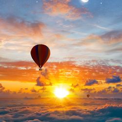 Hot air balloons flying against sky during sunset