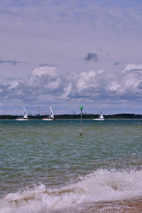 Boats sailing in sea against sky